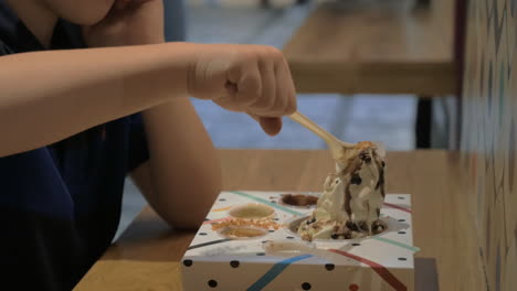 kid eating ice cream in food court of shopping centre