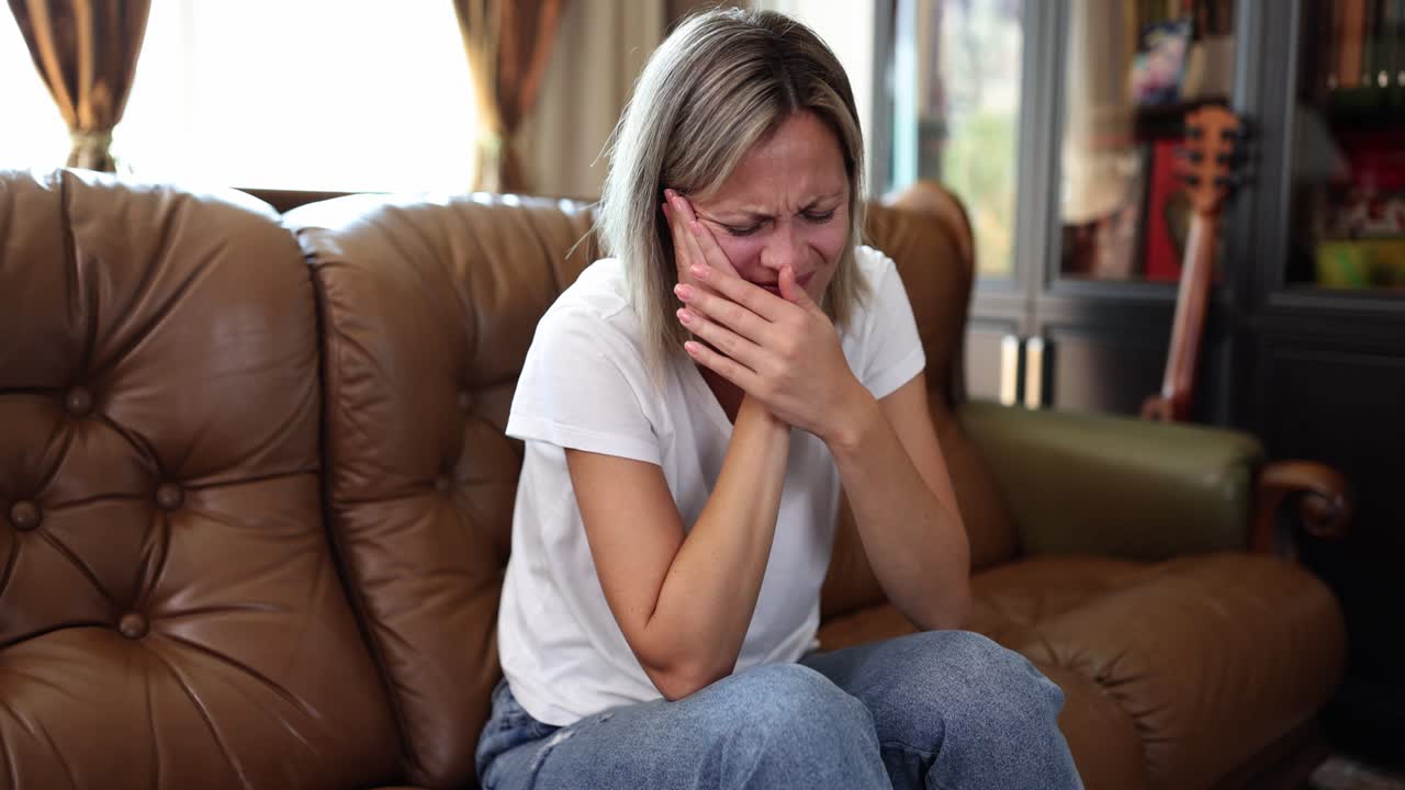 Woman experiencing toothache at home