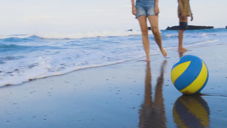 amici che giocano con la palla in riva al mare.