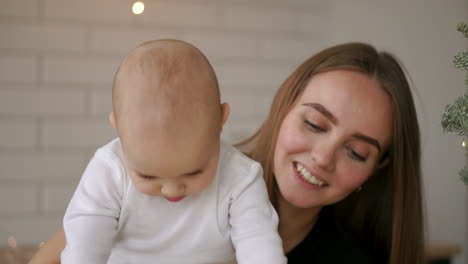 y mamá y bebé sentados en la mesa jugando a la tableta presionando los dedos en la pantalla y riendo