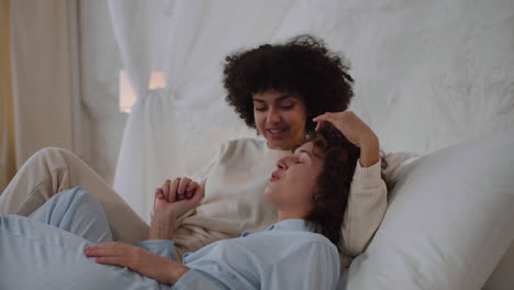 una pareja feliz hablando en la cama.