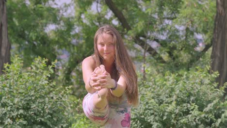 Caucasian-woman-holds-yoga-pose-outdoors-in-nature,-slow-motion-shot