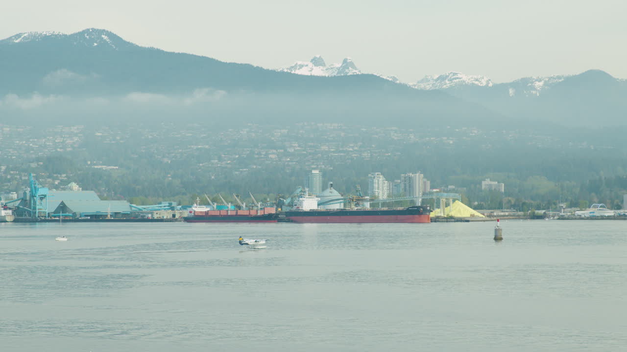 avión acuático despegando en el puerto de vancouver con montañas en el fondo