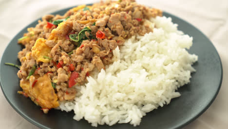 cerdo picado salteado con albahaca y huevo cubierto con arroz - estilo de comida asiática