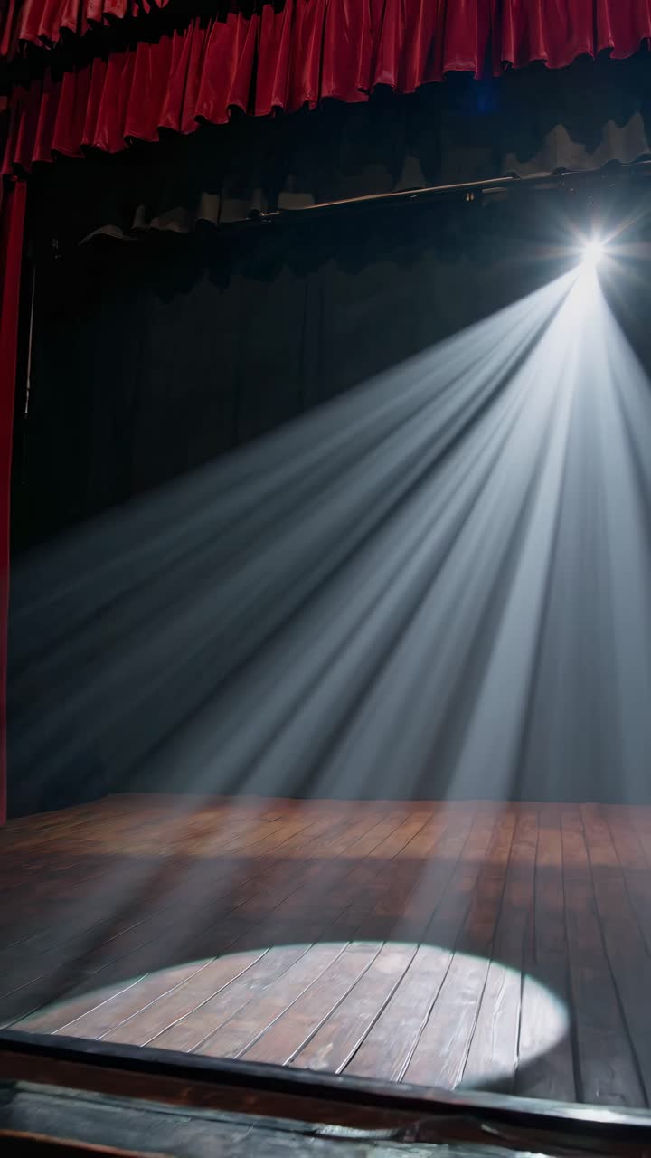 Dramatic stage scene with spotlight beams from above, highlighting wooden floor