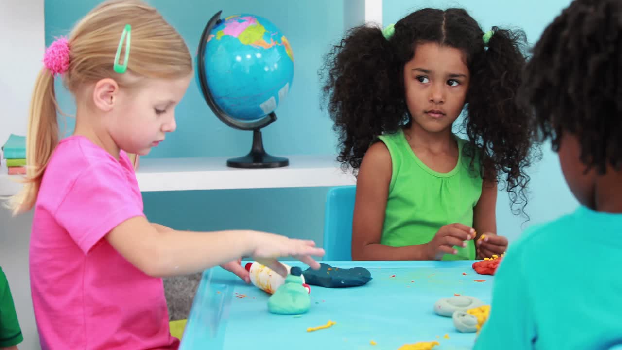 niños pequeños usando arcilla de modelado