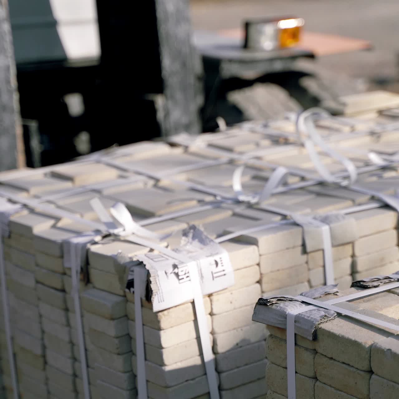 an automatic trolley is stacking pallets with bricks next to each other in the street near the factory. Professional warehouse equipment