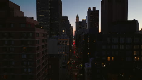 Forwards-fly-above-city.-Silhouettes-of-high-rise-office-downtown-buildings-against-twilight-sky.-Manhattan,-New-York-City,-USA