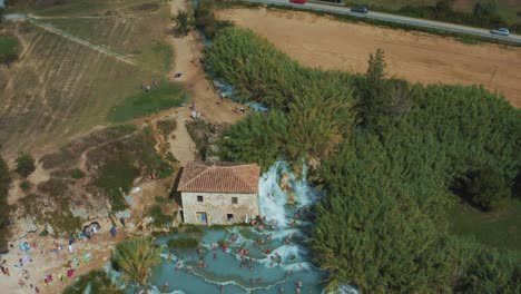 imágenes aéreas de las famosas aguas termales de saturnia cascate del mulino con su agua azul cálida cerca de grosseto en el idílico paisaje de toscana, italia con olivos y campos alrededor
