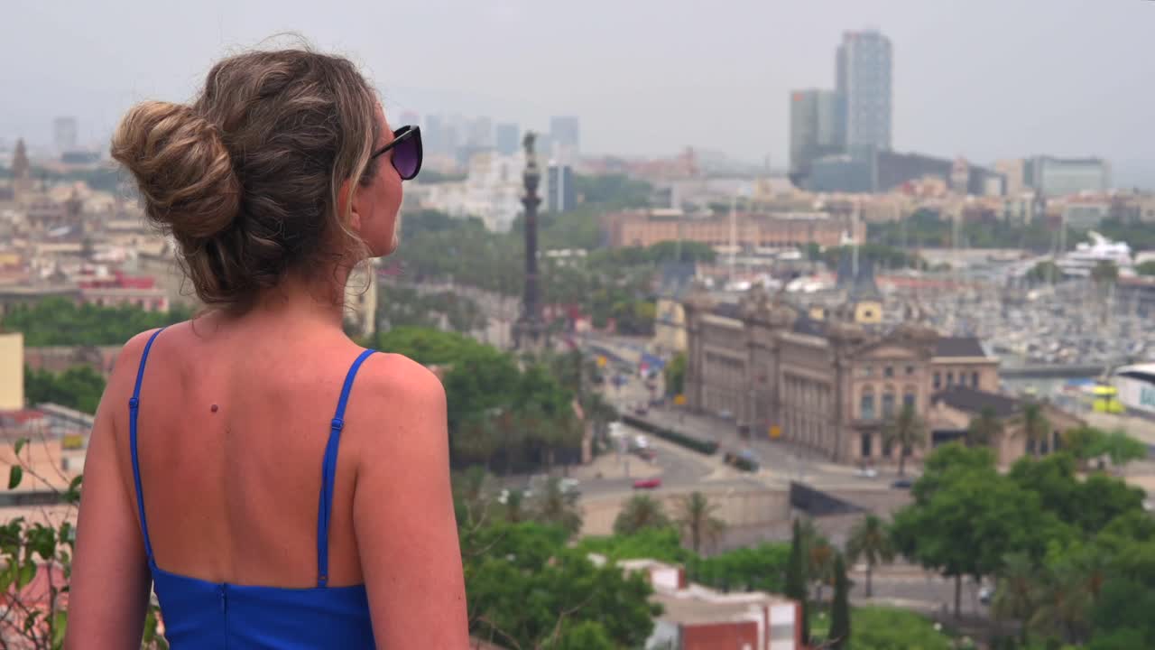 Woman in blue dress looking at the view of Barcelona, Spain
