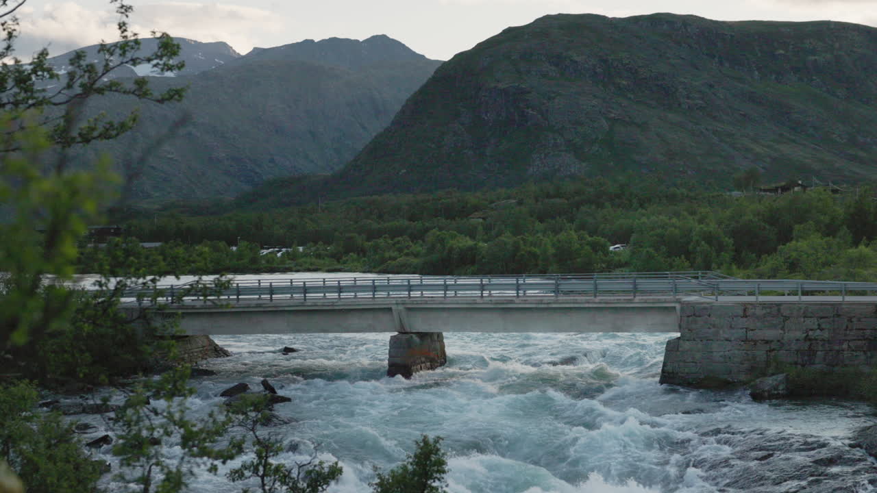 노르웨이 산맥 의 다리 를 건너 운전 하는 오토바이 가 요헤이멘 의 아름다운 풍경 을 여행 하고 있다