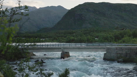 a motorhome driving over a bridge in the norwegian mountains traveling in beautiful landscapes in jotunheimen
