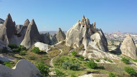 rock cut caves in fairy chimneys in cappadocia landscape, backwards aerial