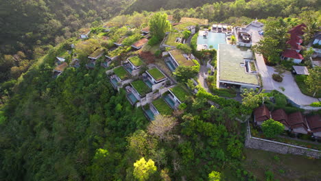 hotel y complejo maua en nusa penida en la cima de una colina rodeado de desierto tropical y naturaleza en bali indonesia, movimiento de paralaje aéreo