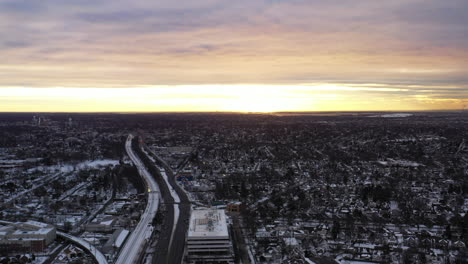 an aerial shot in the suburbs with train tracks and a highway
