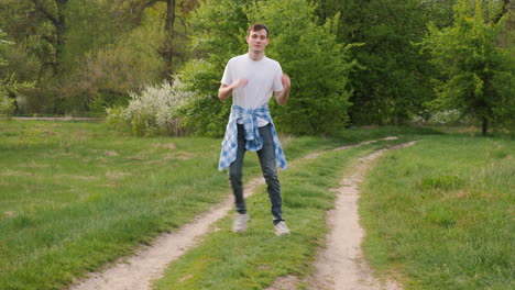 man dancing on a path in a park