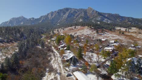 drone aerial rising up to reveal the flatirons nature landscape of boulder, colorado, usa on a snowy fall day