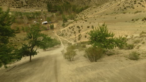 rural road to tourist camp on hill slope fpv drone. dusty footpath trail leading to enthusiastic explorers sports base in valley. wanderlust sense