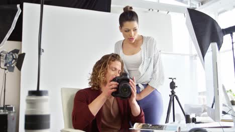 fotógrafos que miran fotografías en una cámara digital