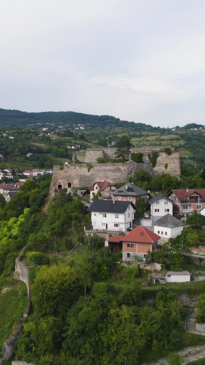 Aerial vertical shot of Jajce Fortress in Bosnia and Herzegovina, surrounded by houses