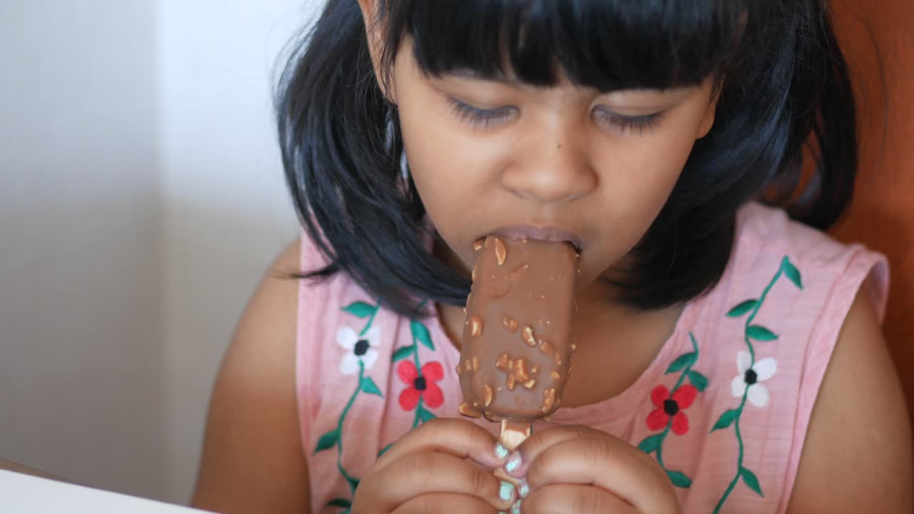 una niña comiendo helado de chocolate