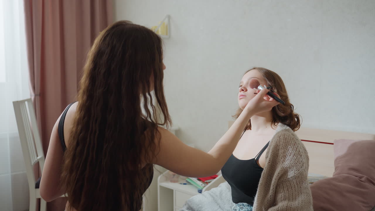 White Woman Receiving Makeup Lesson Friend, Bedroom Setting With Palette And Brush, Gentle Instruction As Artist Demonstrates Blush And Shadow Techniques, Soft Daylight, Relaxed Bonding And Playful