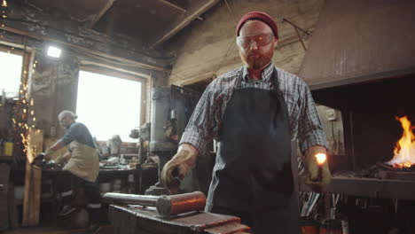 Blacksmith-Taking-Hot-Metal-from-Fire-and-Hammering-It-on-Anvil