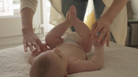 newborn baby feet and fingers, mom massages circles with hands