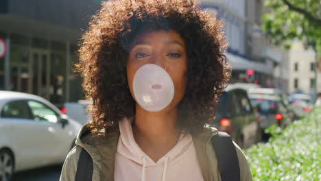 woman blowing bubblegum in city street