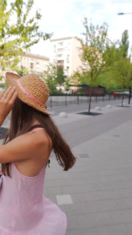 young woman outdoors with straw hat and camera