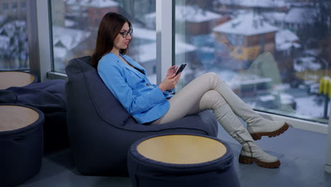 mujer usando un teléfono inteligente en un café moderno