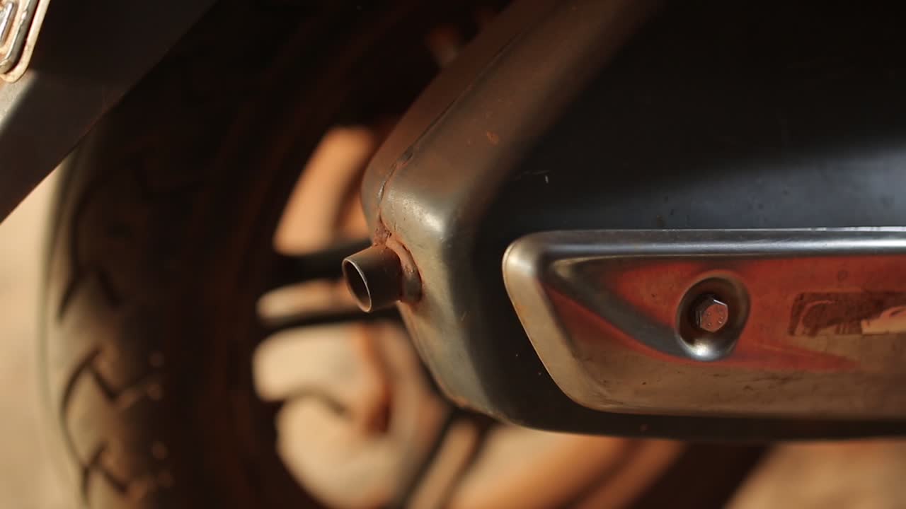 viejo escape y silenciador en moto con luz dorada