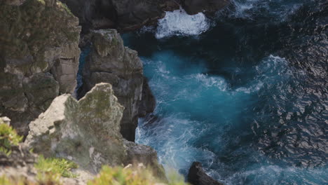 slomo from above of ocean waves hitting cliffs by coast at the azores