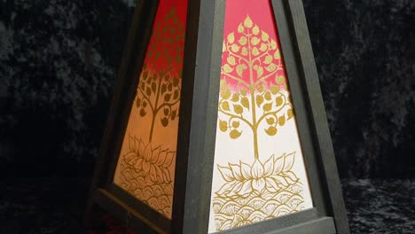 An-upward-pan-of-an-Asian-inspired-desk-lamp-turning-on