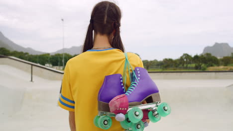 rearview of a female roller skater carrying skates