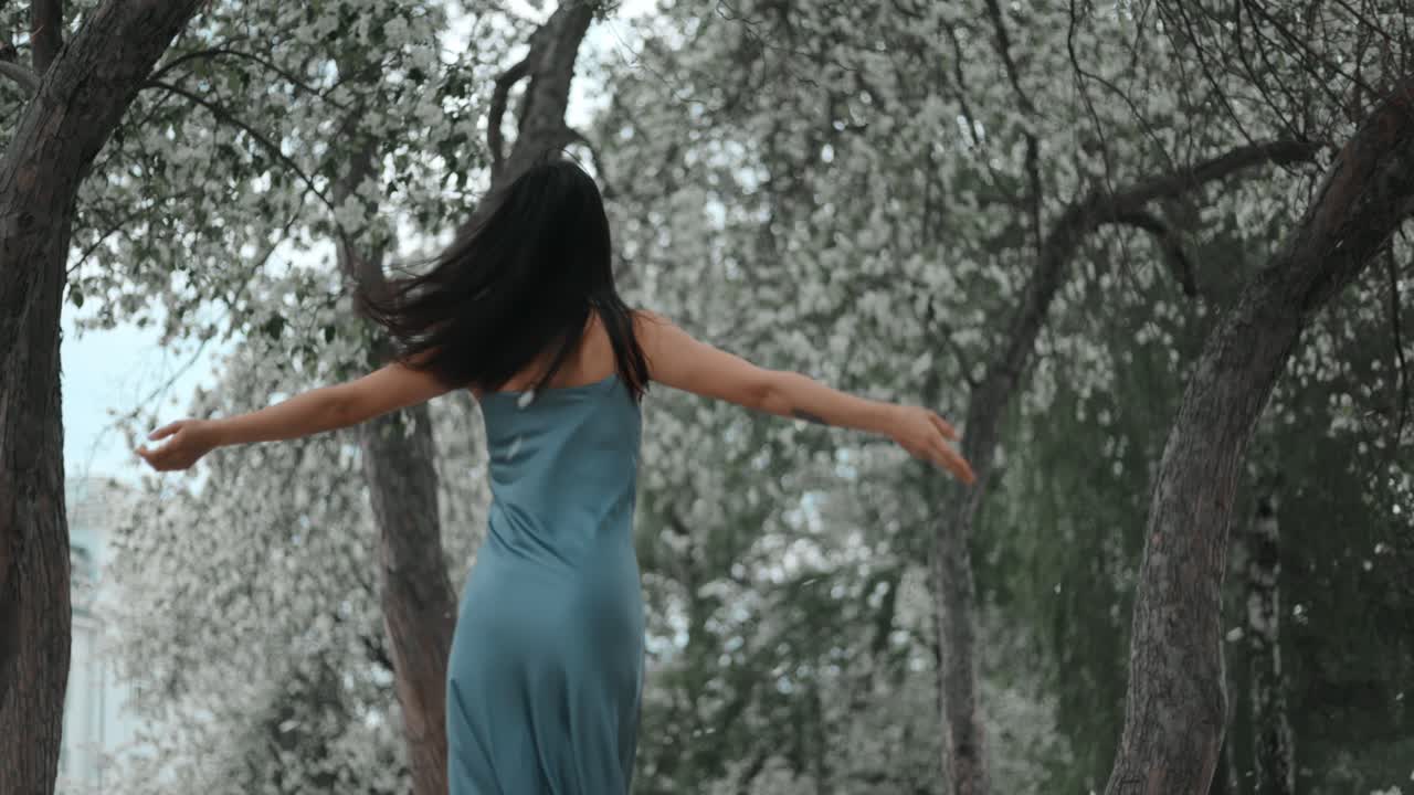 Woman in a blue dress amidst spring flowers