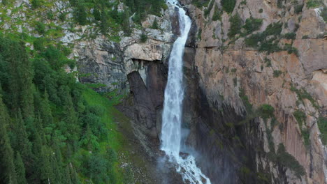 drone shot barskoon waterfall in fairy tale canyon in kyrgyzstan, rotating aerial footage, wide