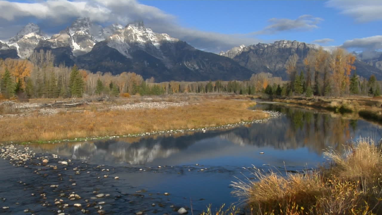 grand teton-bjergene afspejles i en bjergflod.