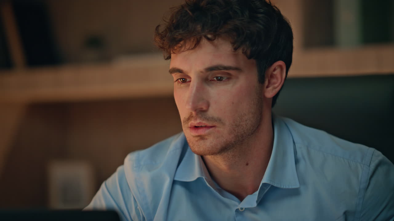 Primo piano: imprenditore stressato che reagisce emotivamente a un fallimento in un luogo di lavoro buio.