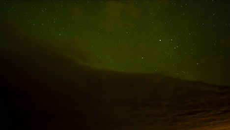 Hermoso-Lapso-De-Tiempo-De-Auroras-Boreales-Verdes-Sobre-Nubes-Oscuras-Con-Un-Cielo-Nocturno-Estrellado-Con-Estrellas-Fugaces