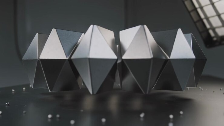 Rotating dark metal object levitating over black desk in studio revealing faces, beads