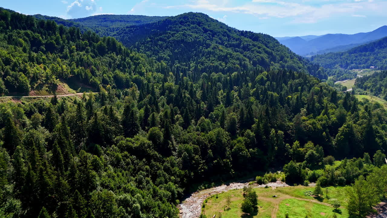Scenic view of lush mountains and river. Lush green mountains surround a winding river under a bright blue sky in a peaceful natural landscape