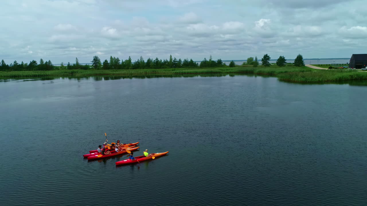 personas en kayak en un lago tranquilo con un paisaje verde y casas cercanas