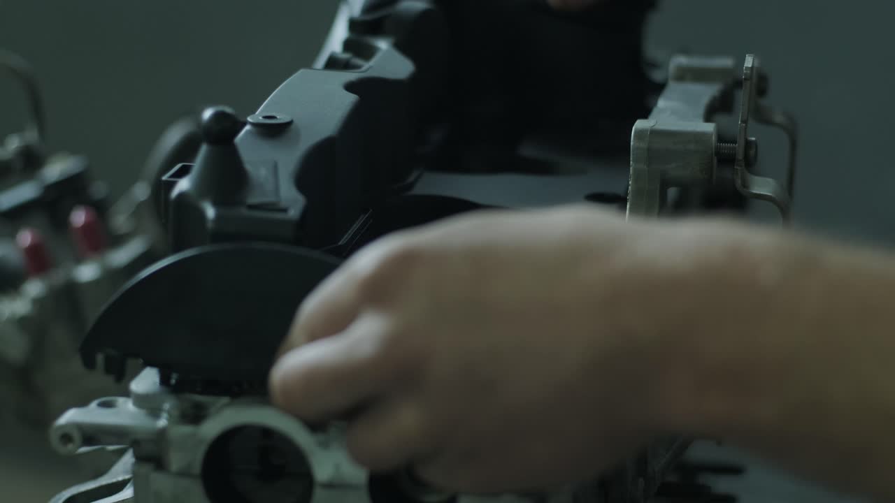 An auto mechanic in a garage closes the cover of a car engine. Mechanic hands closes the engine after repair. Car service