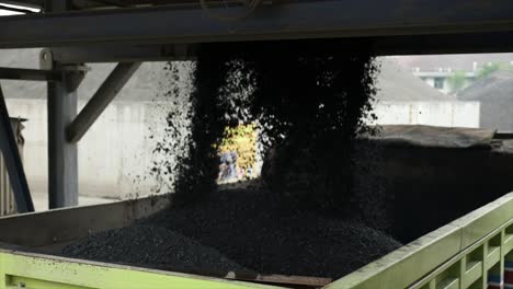 process of pouring the mixed and homogeneous aggregate into the transport truck by opening the opening door at the bottom of the mixer with hydraulic control at the asphalt mixing plant factory