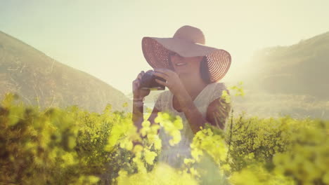 woman in a field of flowers taking pictures