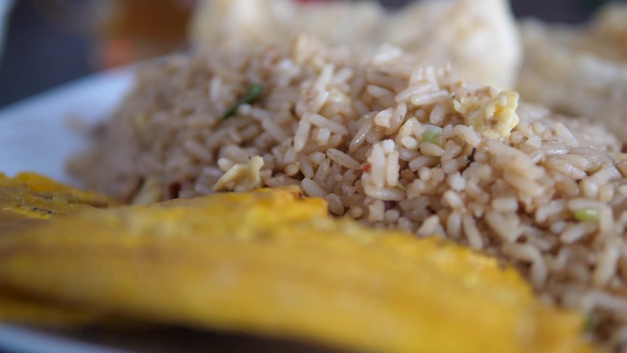 Close-up de arroz frito e banana no prato.