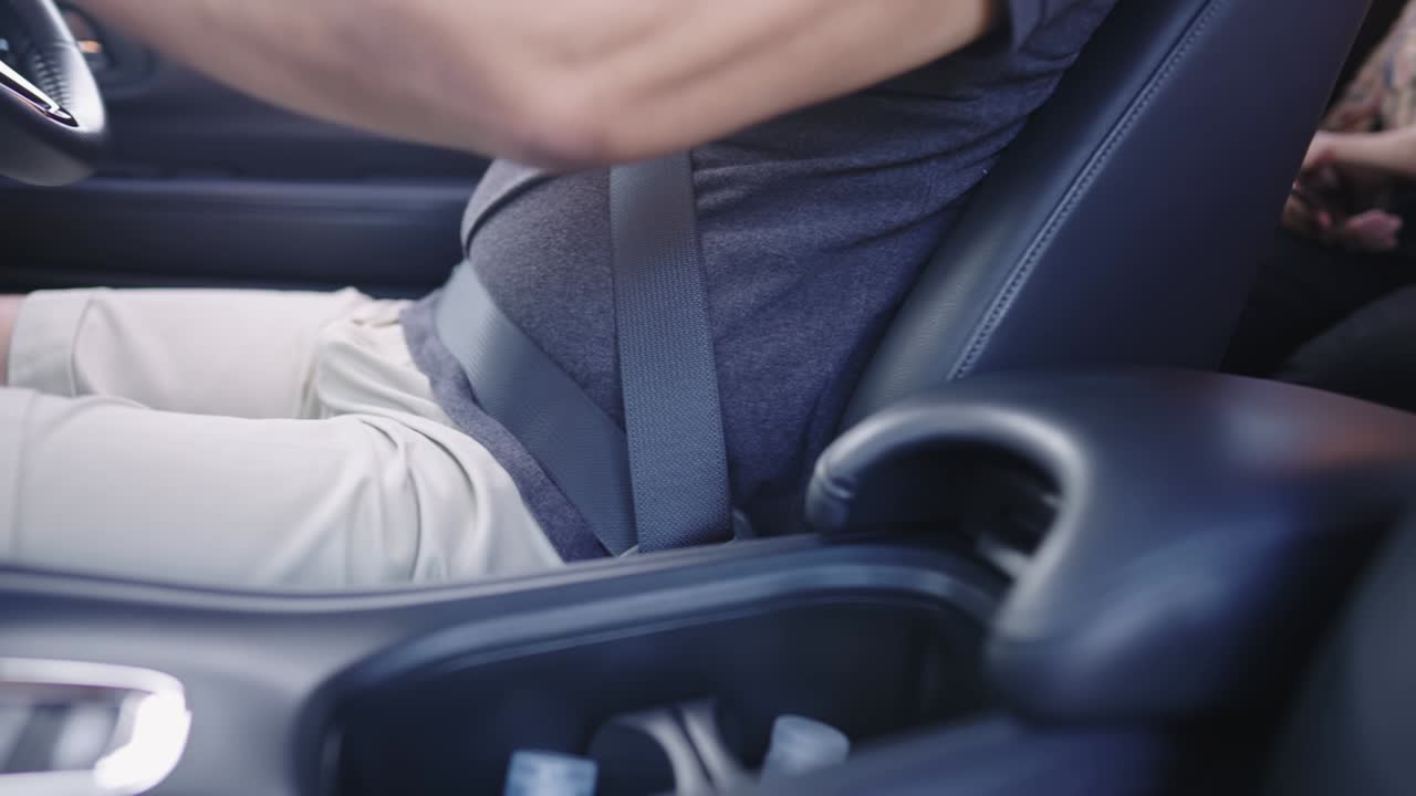 남자 운전자의 근접 촬영: 운전하기 전에 안전벨트를 고 준비하십시오. 안전이 우선입니다.