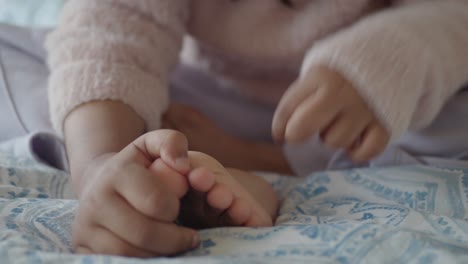 a child is playing with their feet on a bed