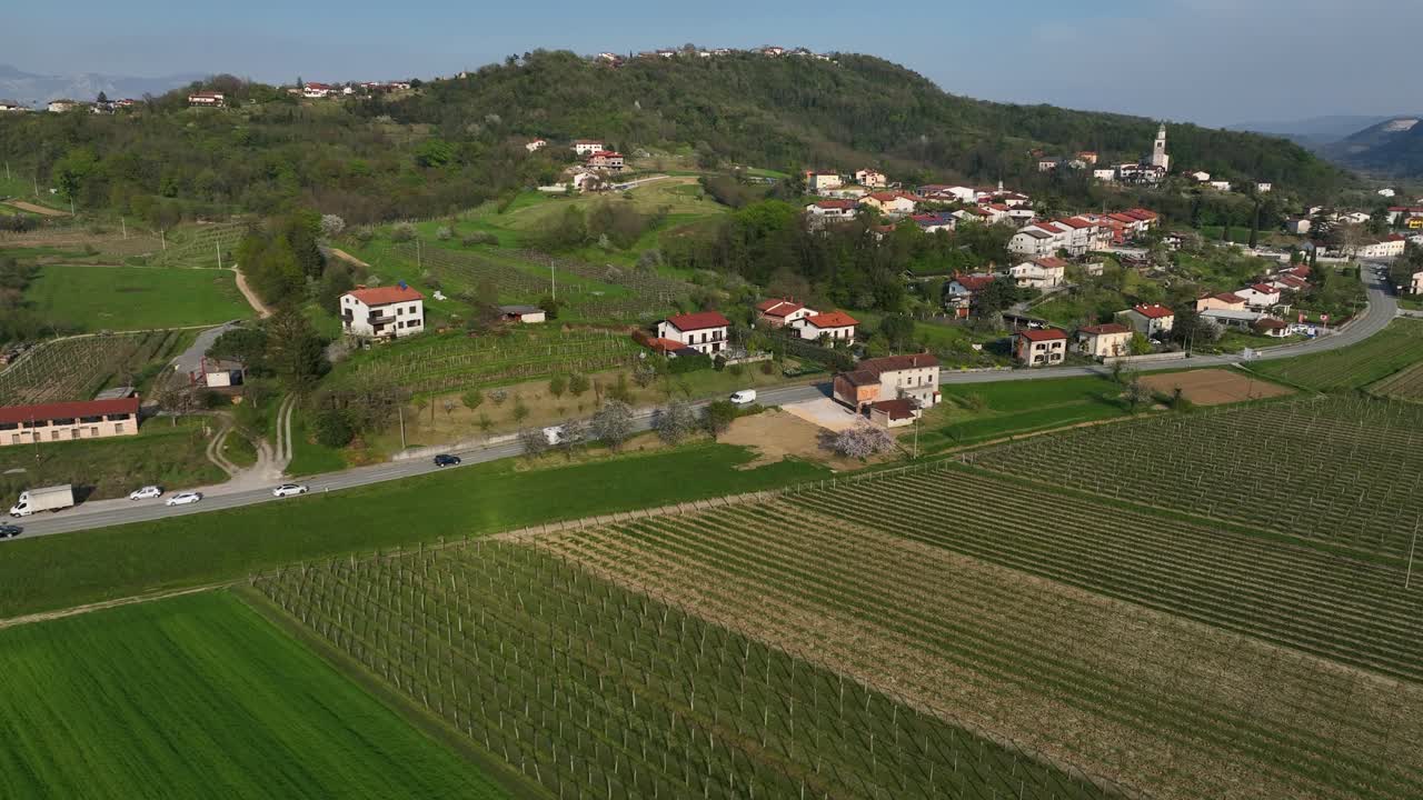 Tracking drone shot of white van and two cars on a road during the day in Vipava, Inner Carniola, Slovenia